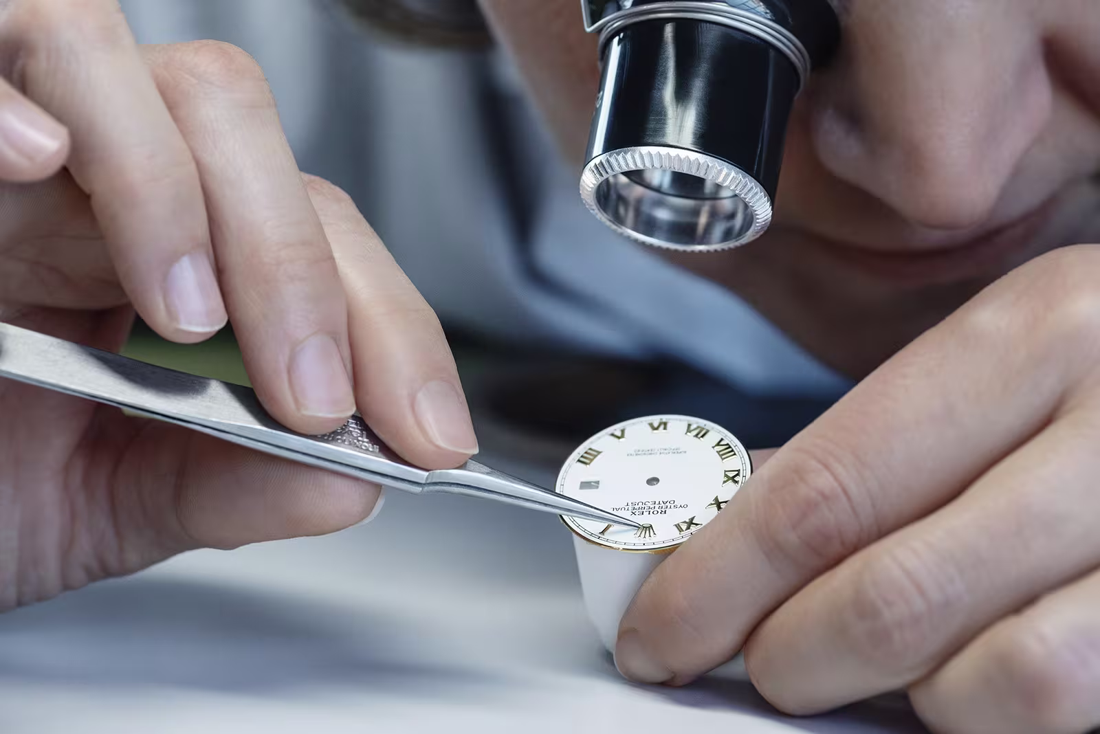 Professional watchmaker carefully working on a Rolex dial restoration
